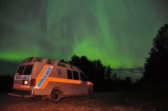 Ambulance in rural area in front of the northern lights, aurora borealis